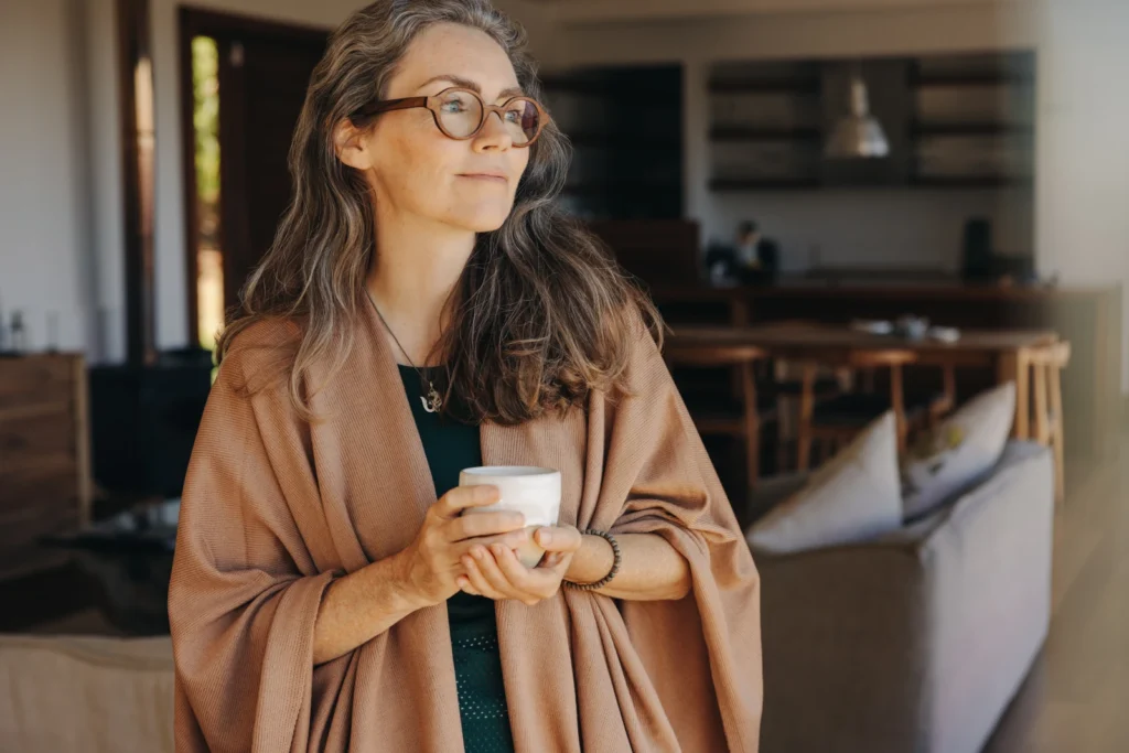 Frau mit Kaffeetasse blickt in die Ferne